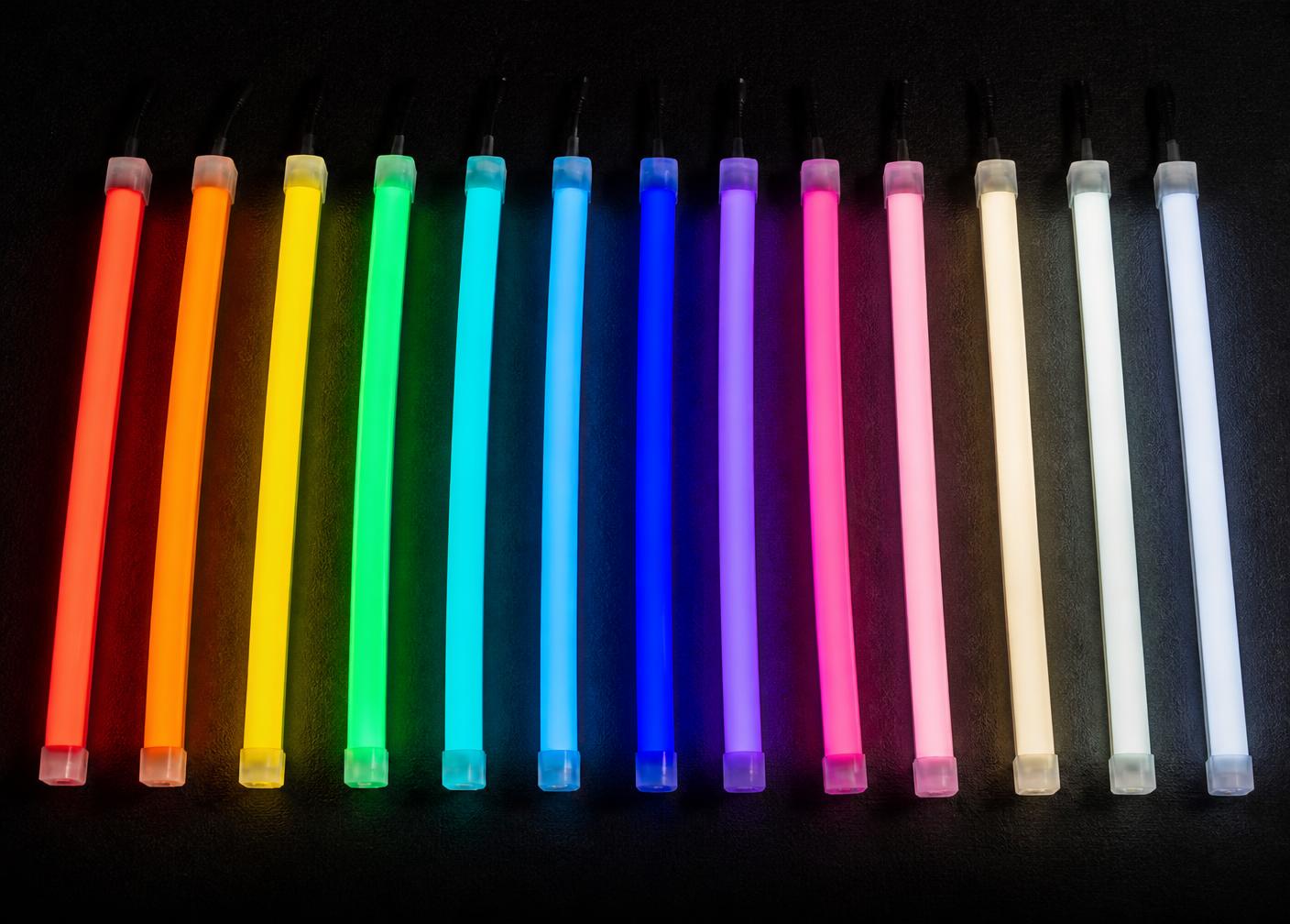 Fourteen lit LED neon flex samples laid side by side in different colours on a black surface